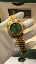 Yellow Gold with green Dial.